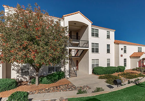 3-story stucco apartment building with adobe-style brick roofing